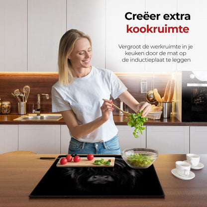 Vrouw in de keuken bezig met eten voorbereiden met behulp van de inductie beschermer Schotse hooglander