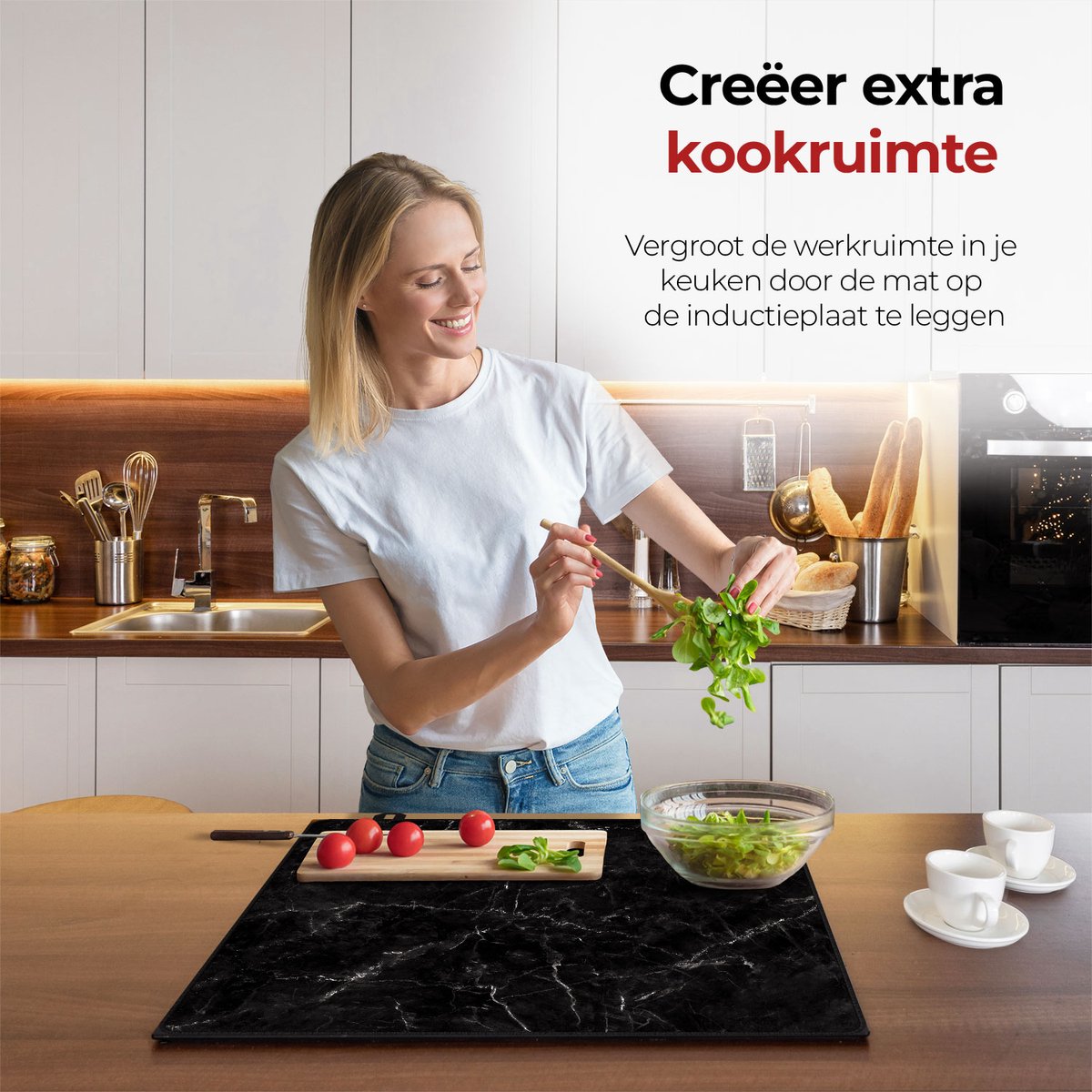 Vrouw in de keuken bezig met eten voorbereiden met behulp van de inductie beschermer marmer zwart en wit